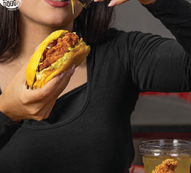 Close-up of a bite into a crispy chicken burger