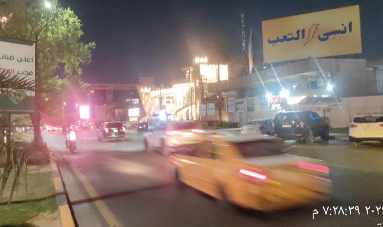 Digital billboard at night on a Baghdad main road - 'Forget Fatigue' out-of-home placement