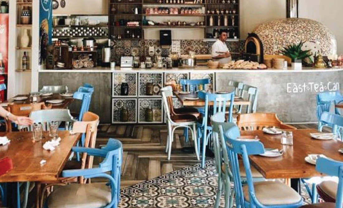 Cafe interior with blue chairs, wooden tables and the counter