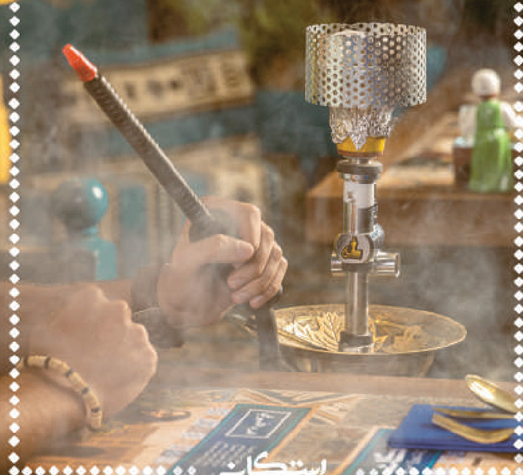 Hands preparing a shisha with drifting smoke