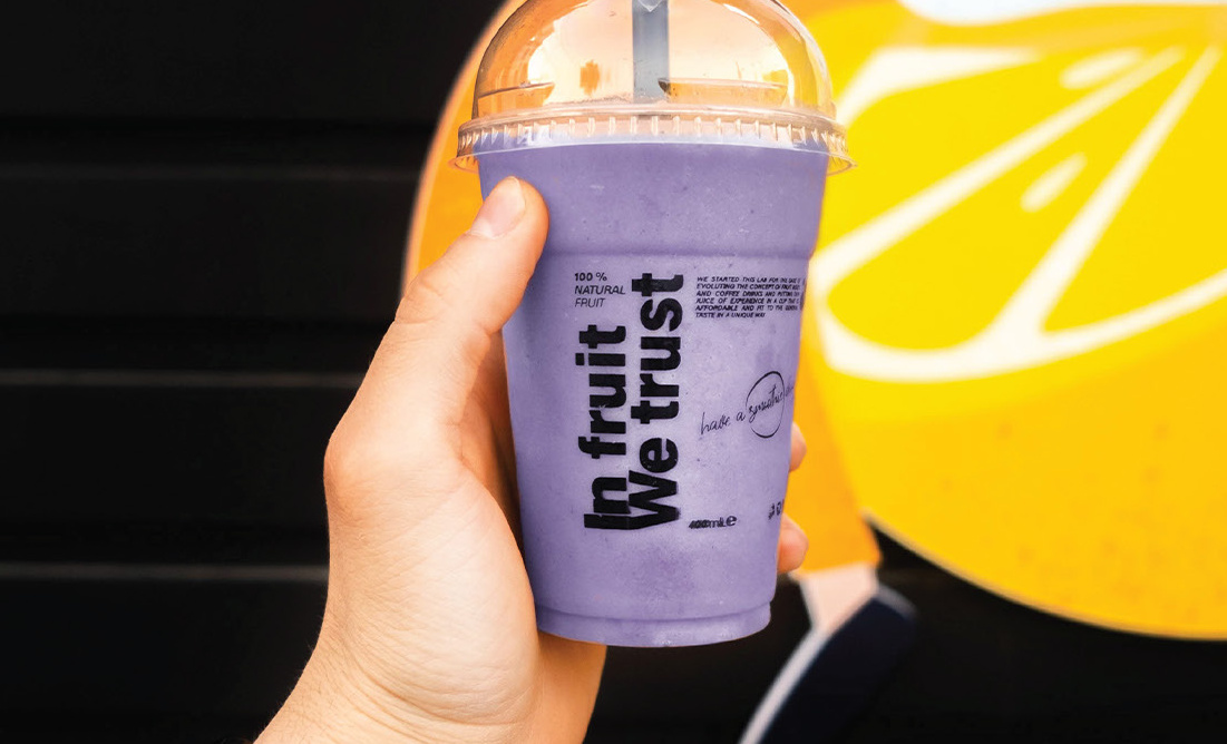 Purple 'In fruit we trust' cup against a lemon graphic
