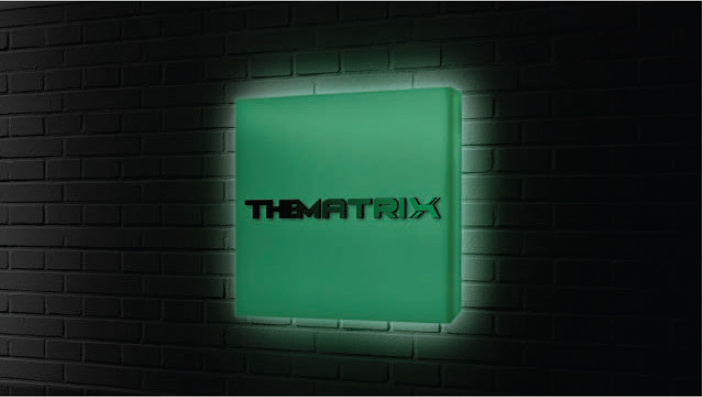 Backlit green sign box on a black brick wall